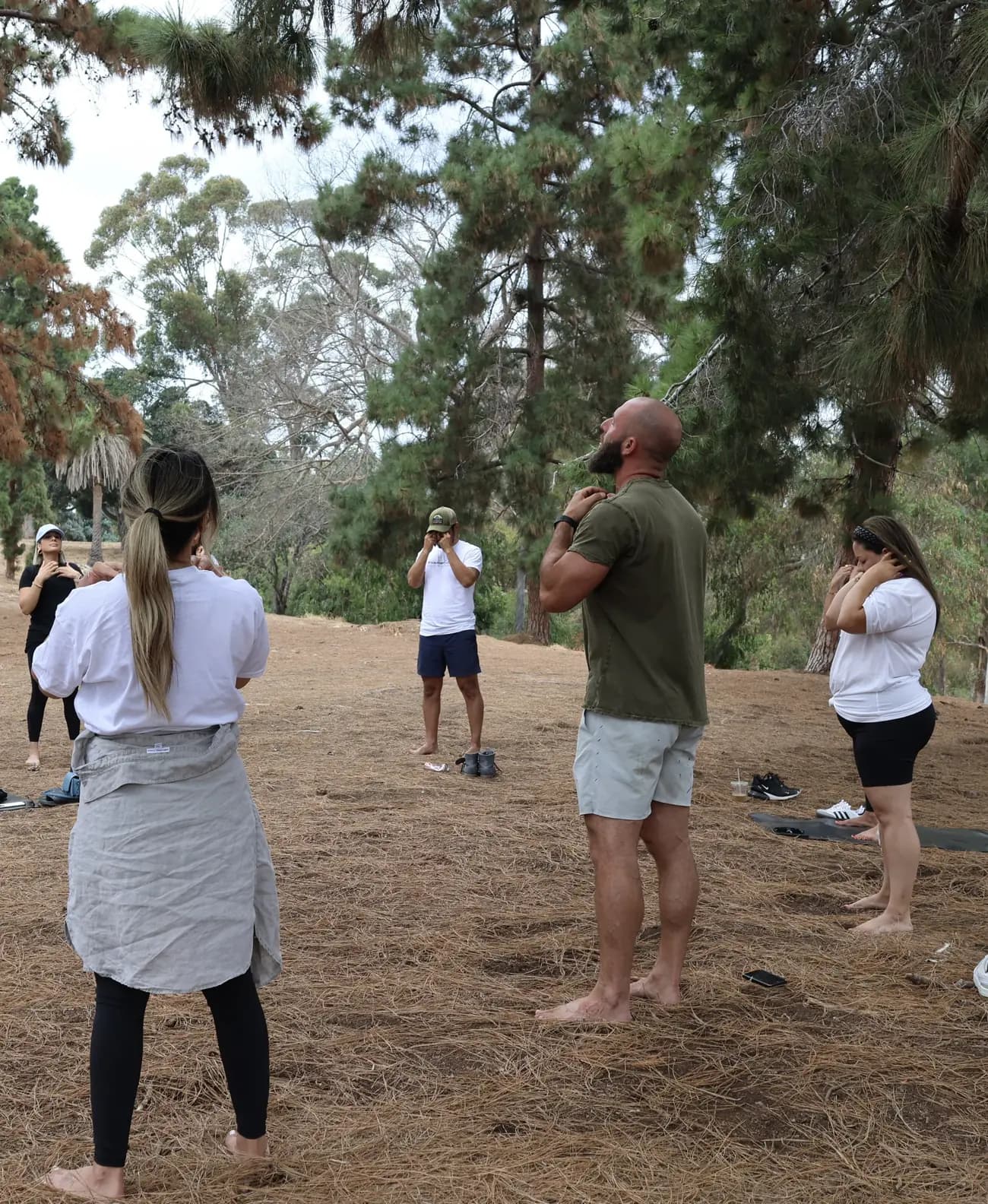 Miles leading a small group through a standing breathwork practice outdoors